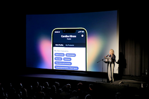 Caroline Hirons presents the Skin Rocks app on a large screen to an audience in a darkened theater.
