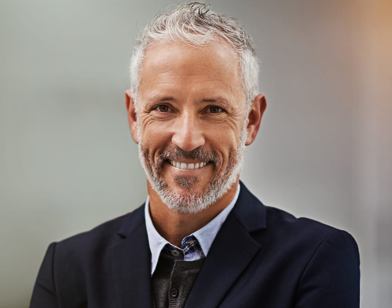 older man in a black suit smiling