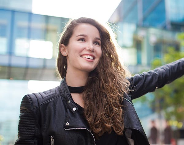 woman with long brown curly hair in a black leather jacket