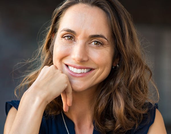 woman with long brunette hair wearing a black top