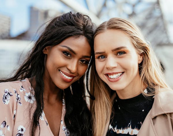 two women standing next to eachother smiling