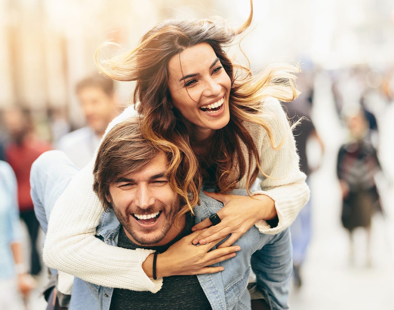 a woman on top of a man's back, walking down a street