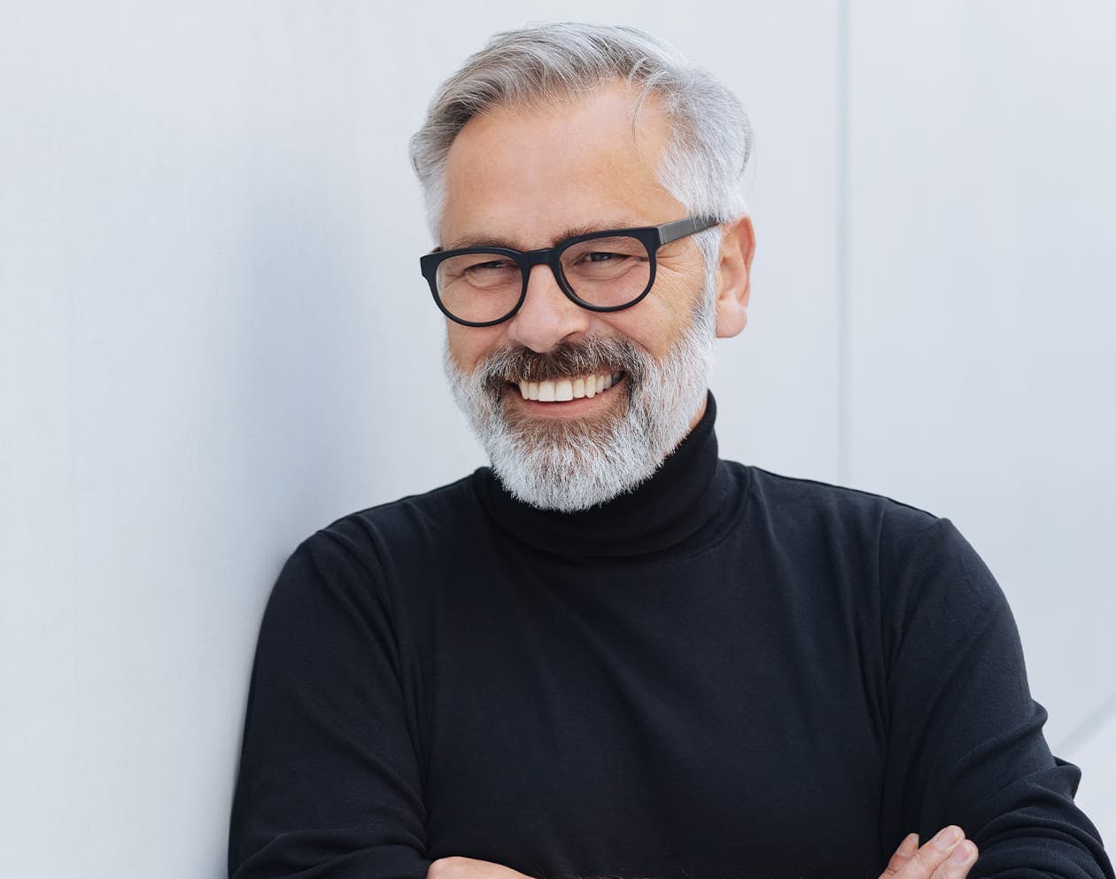 an image of an older man with grey hair in a black turleneck sweater