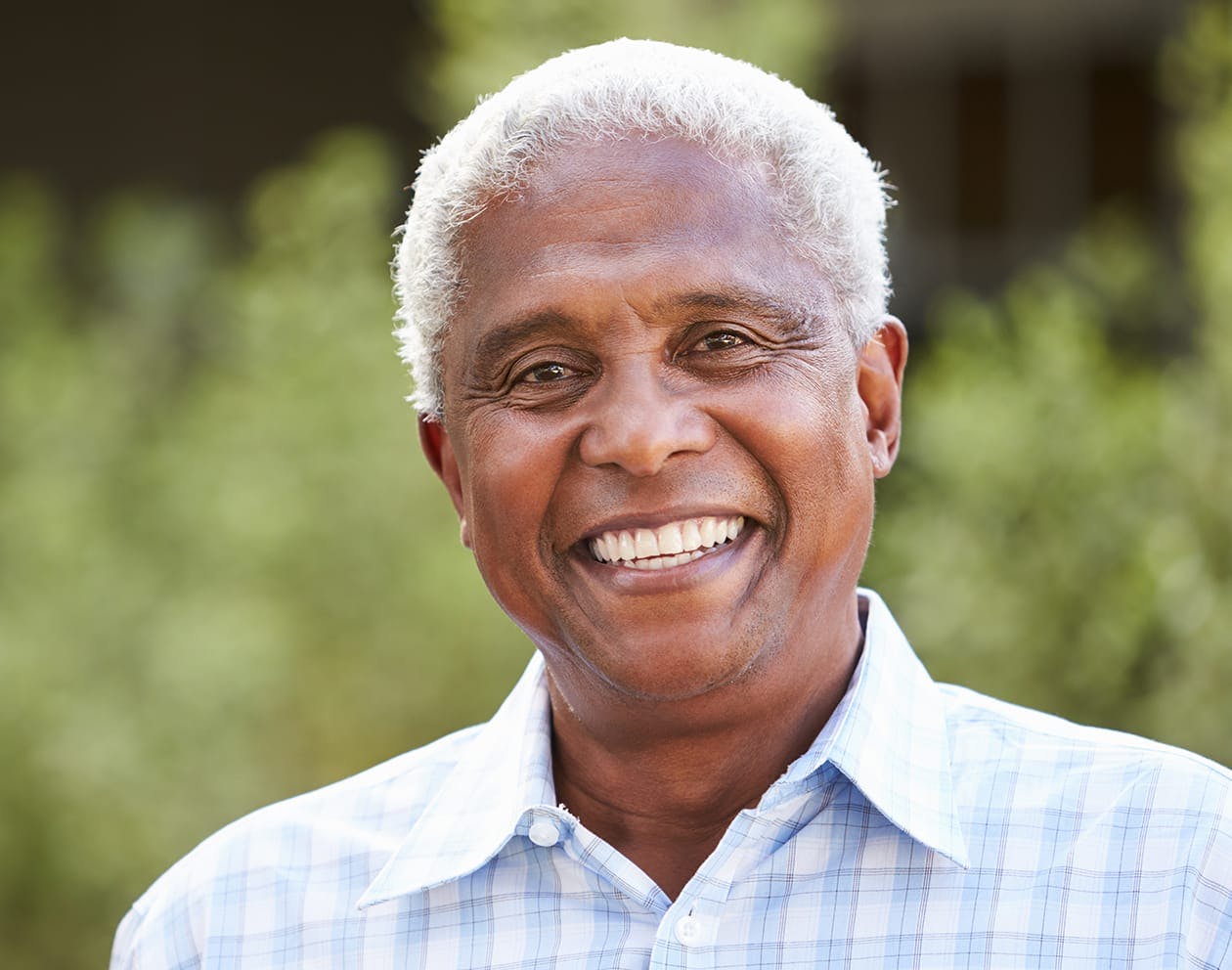 an image of an older black man smiling in a light buttondown shirt