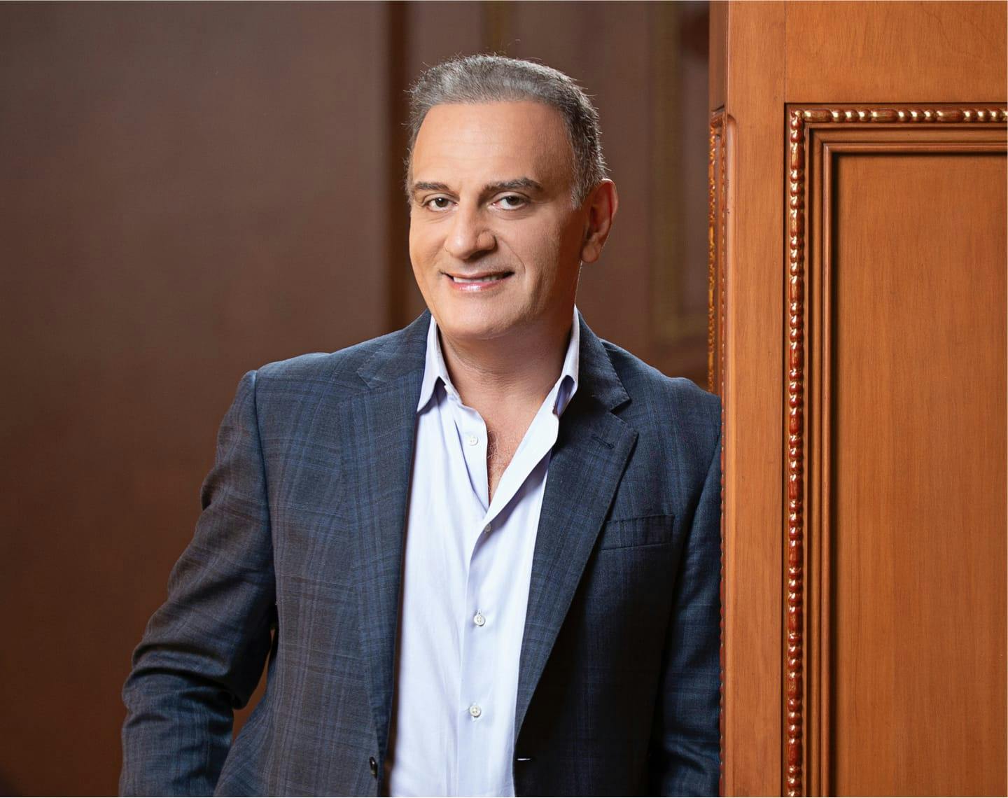 Dr. Maddahi smiling in a plaid suit jacket.