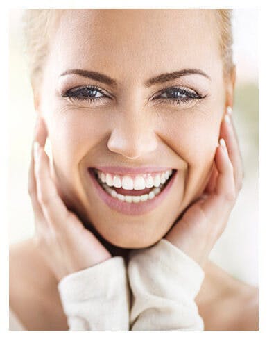 woman smiling really big with her hands up to her face