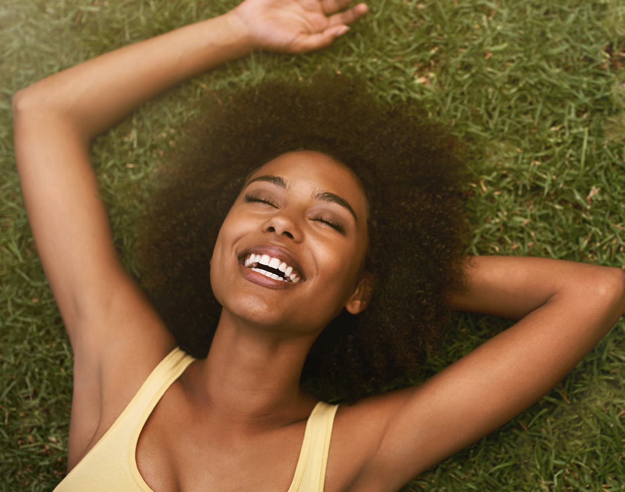 woman with brunette hair laying in the grass