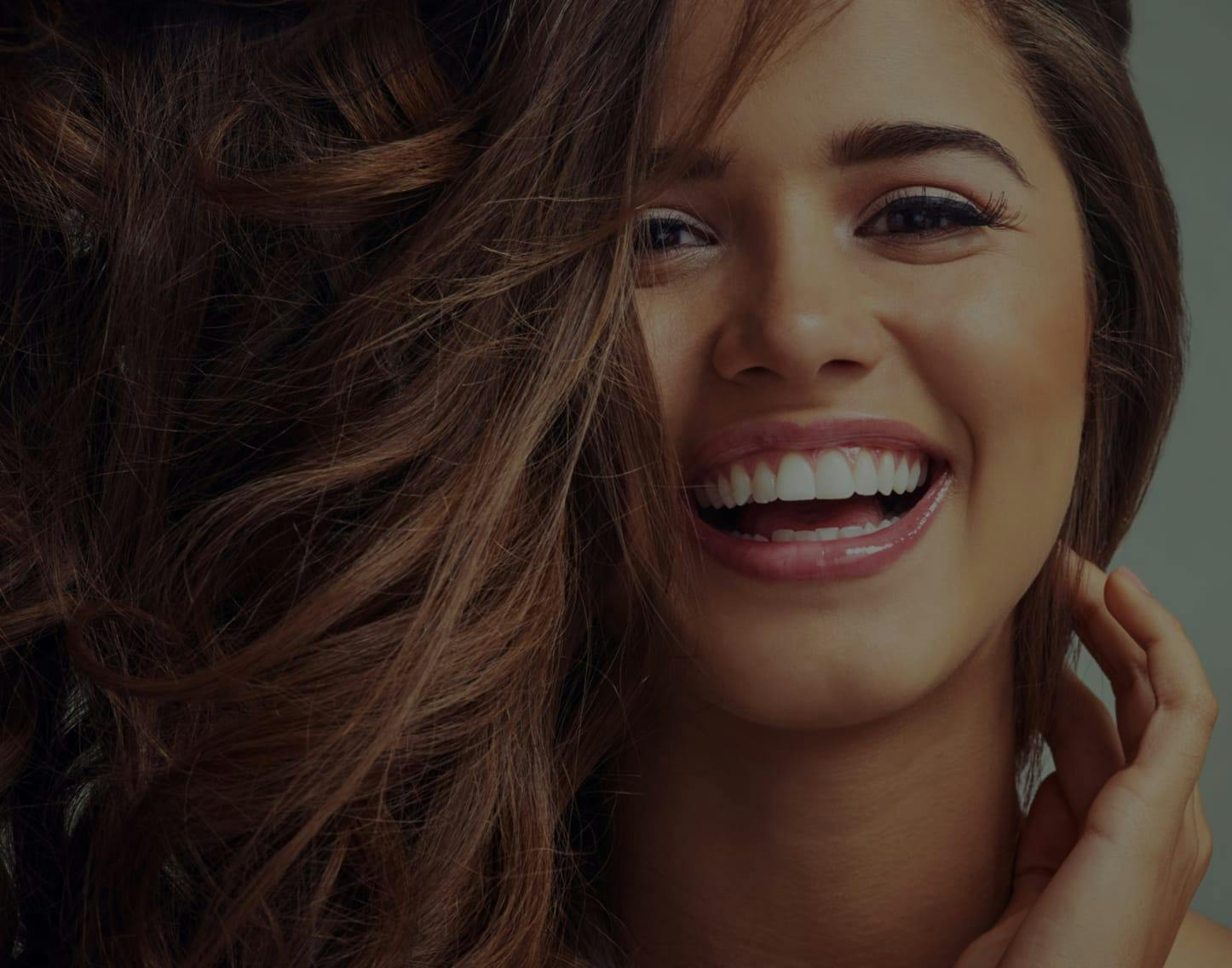 Beautiful young woman smiling with her hand in her hair.