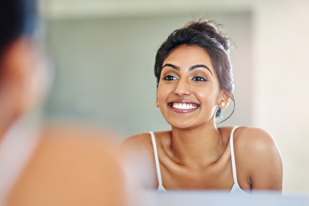 Beautiful woman smiling in mirror.