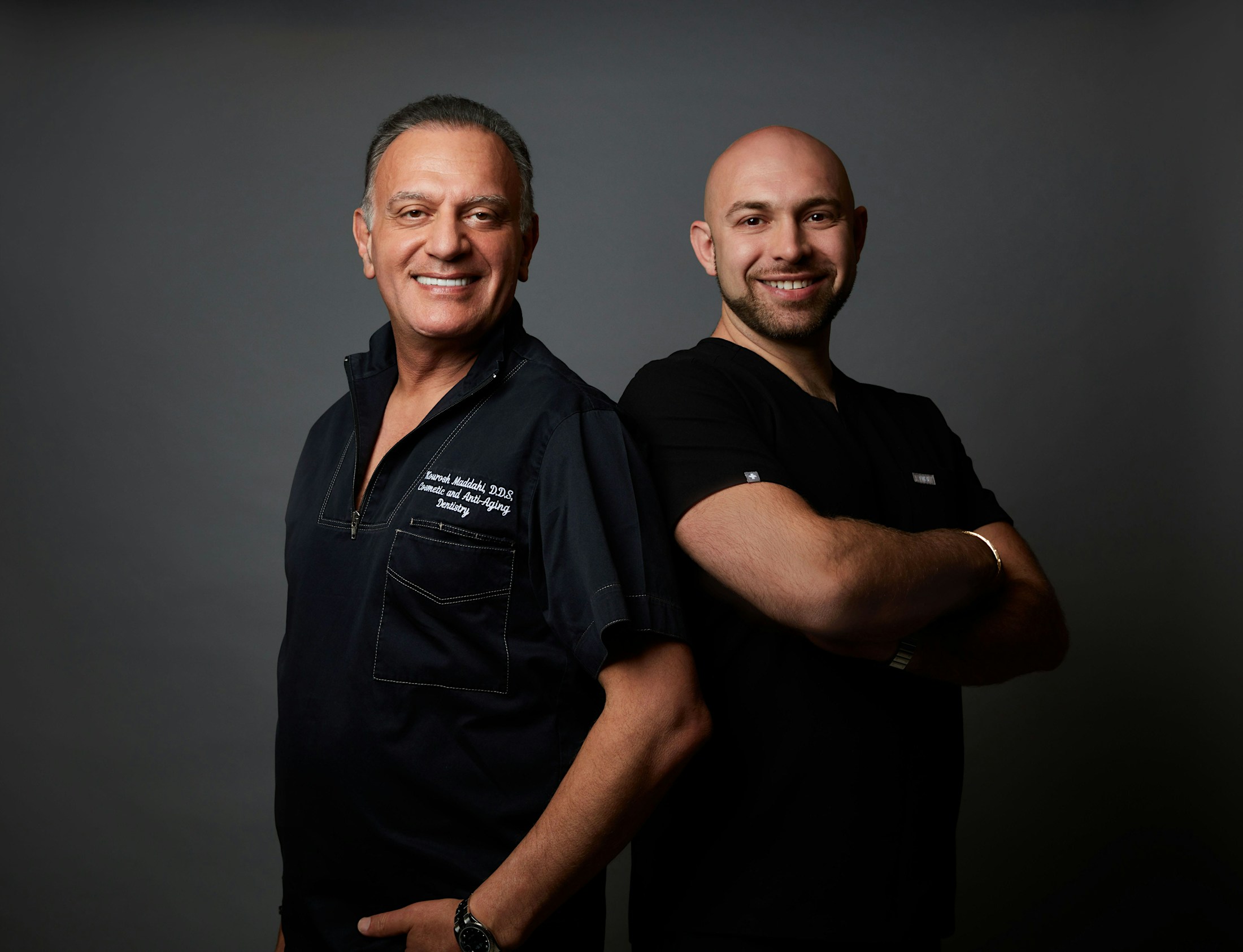 Dr. Maddahi and Samadian standing back to back in scrubs