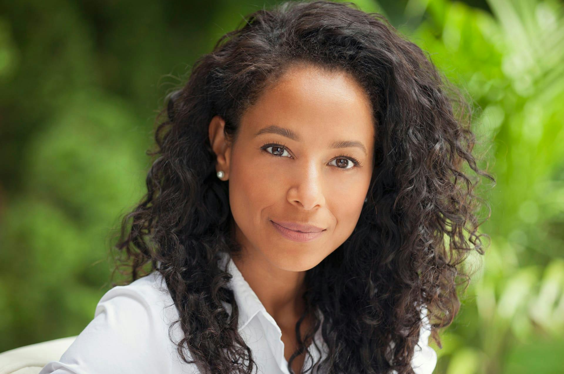 Woman in a white top and curly black hair