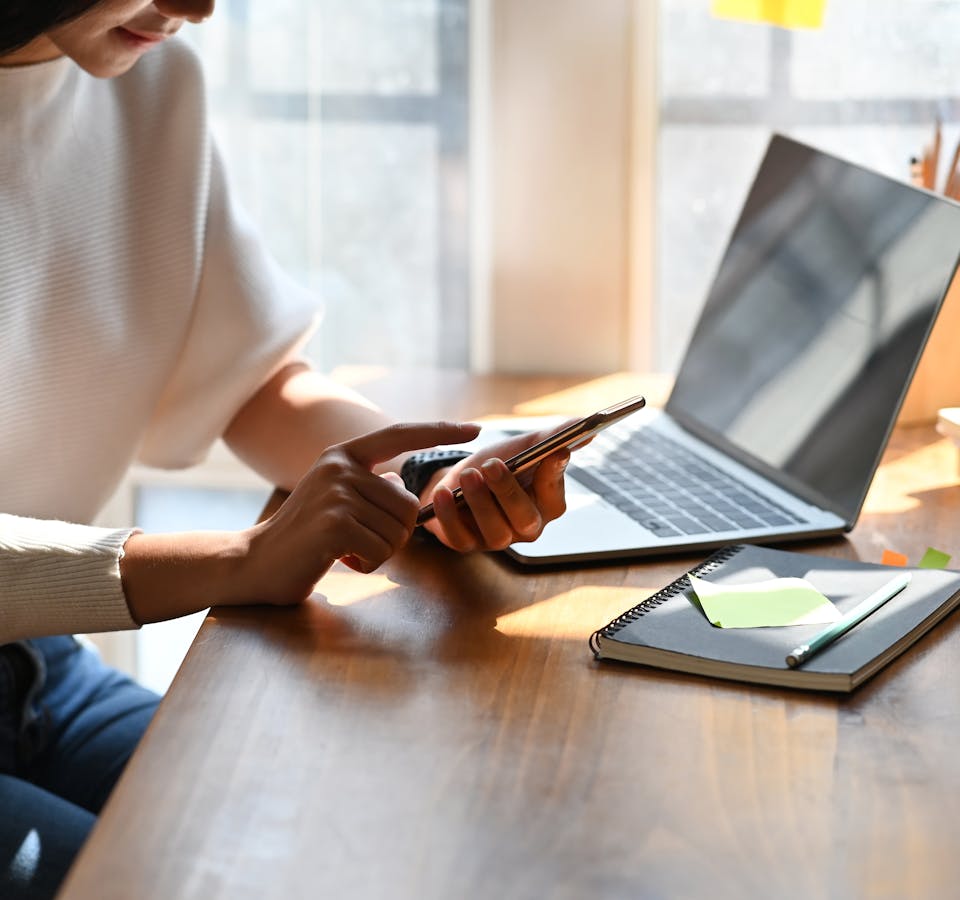 Image recadrée d'une femme travaillant sur un smartphone