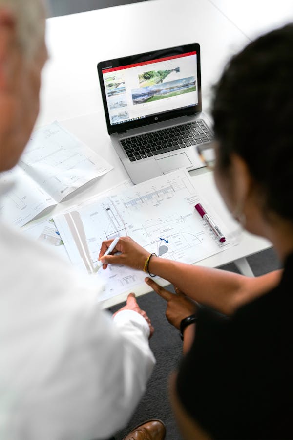 Gros plan de personnes travaillant sur des plans au bureau.