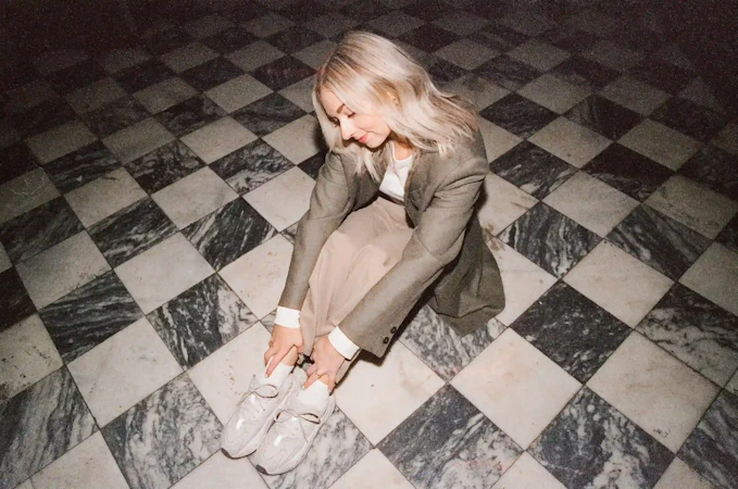 Tiffany seated on a checkered tile floor