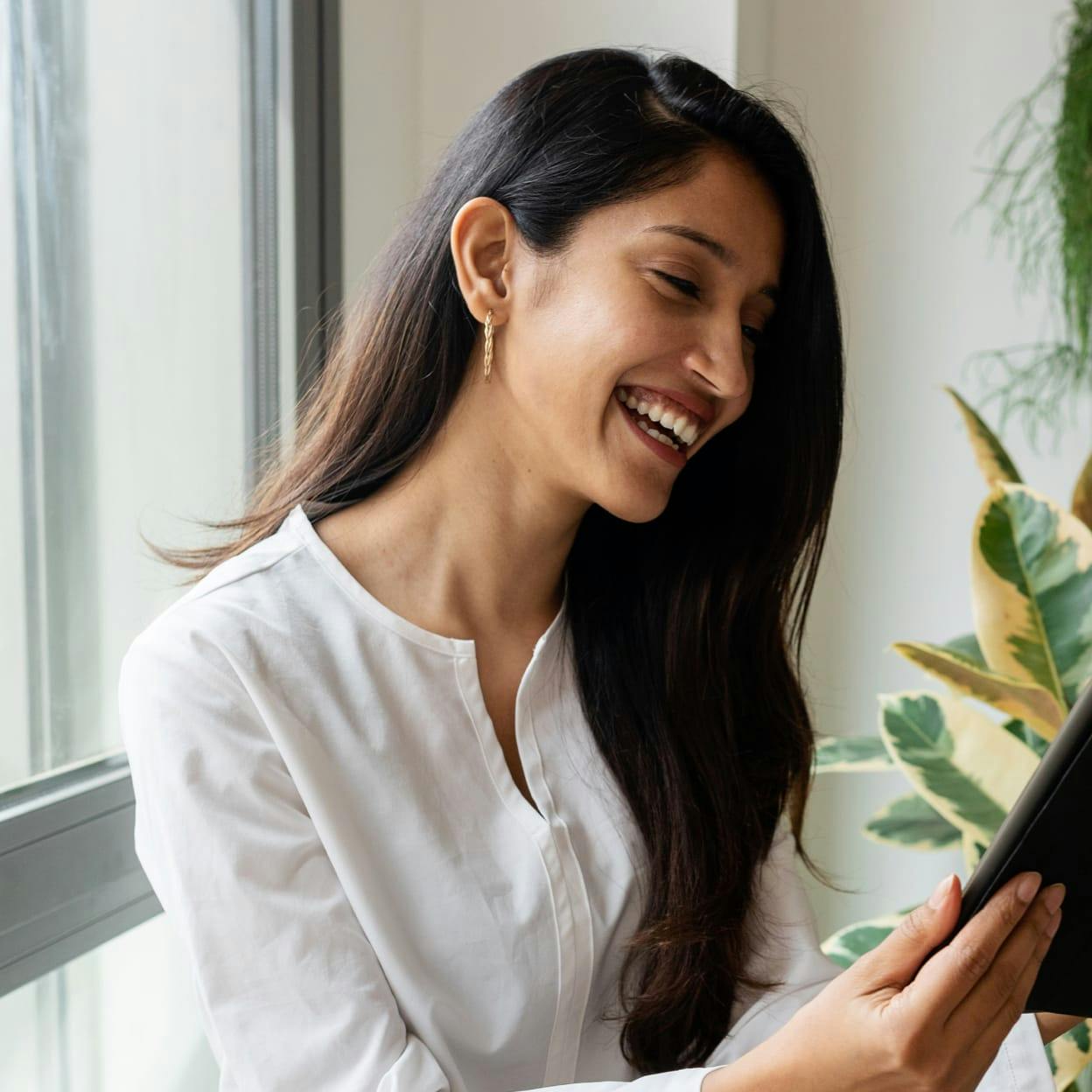 Beautiful woman smiling while looking at a tablet