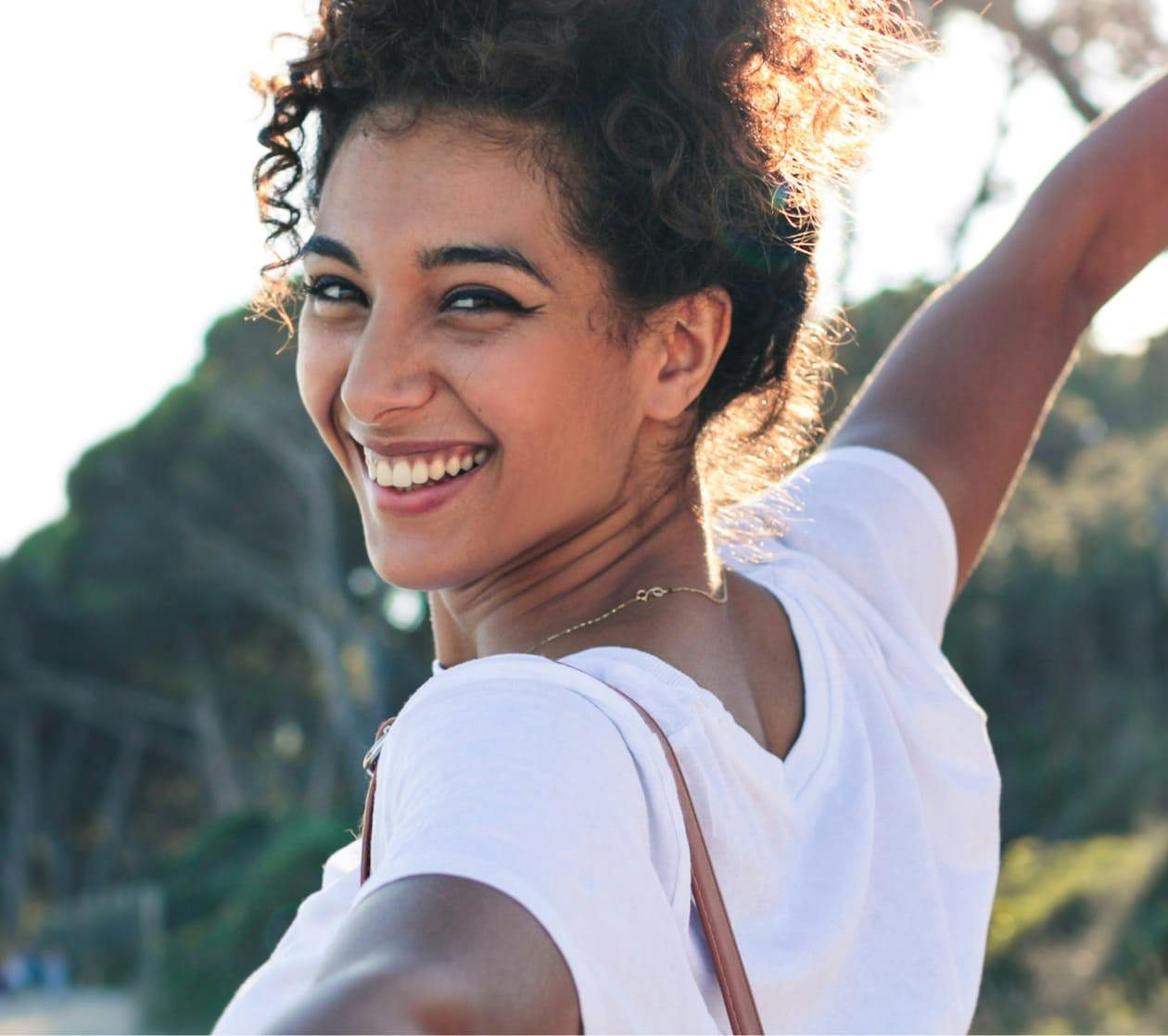 Beautiful woman looking at the camera, smiling and holding her arms out