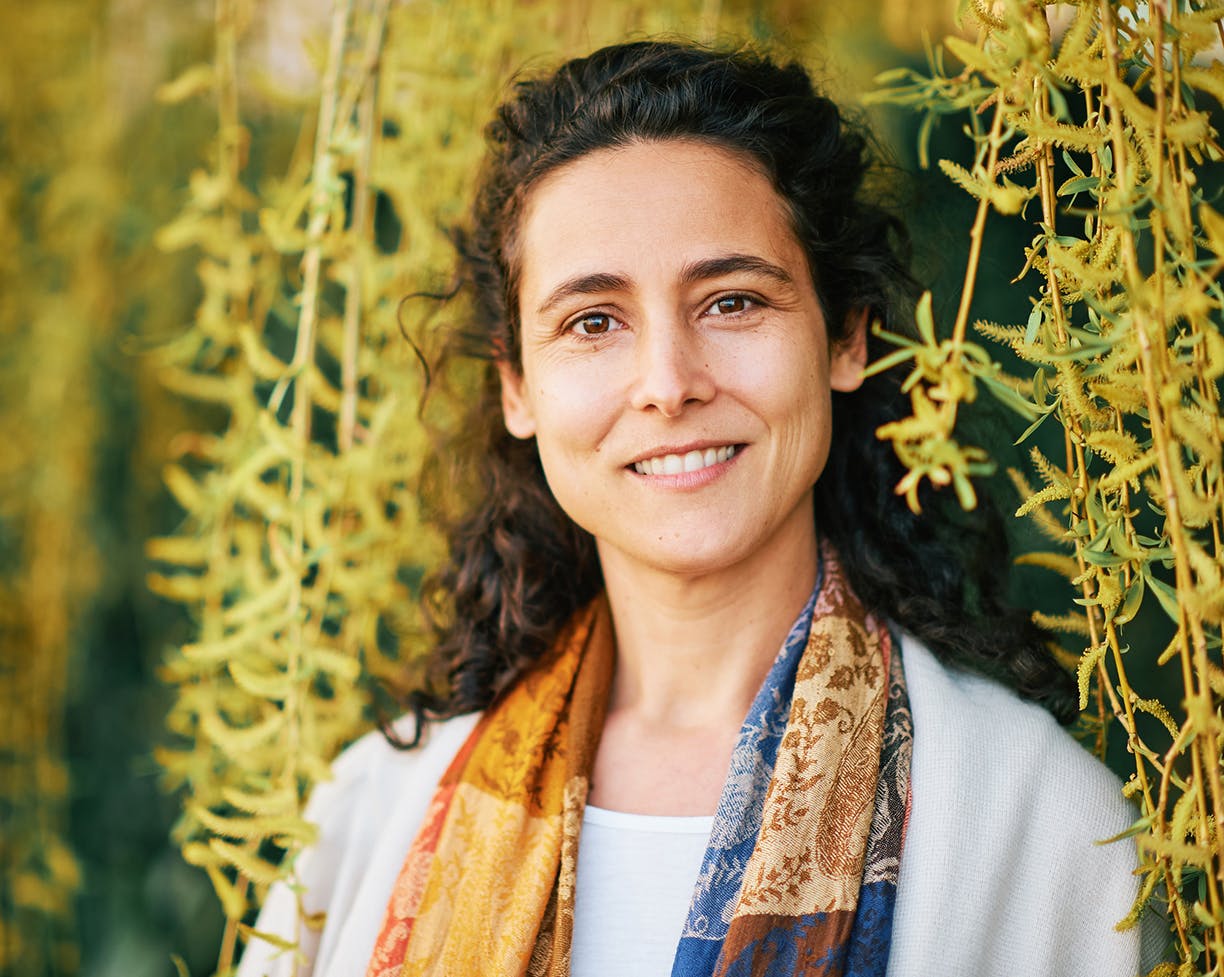 Woman smiling under yellow flowers