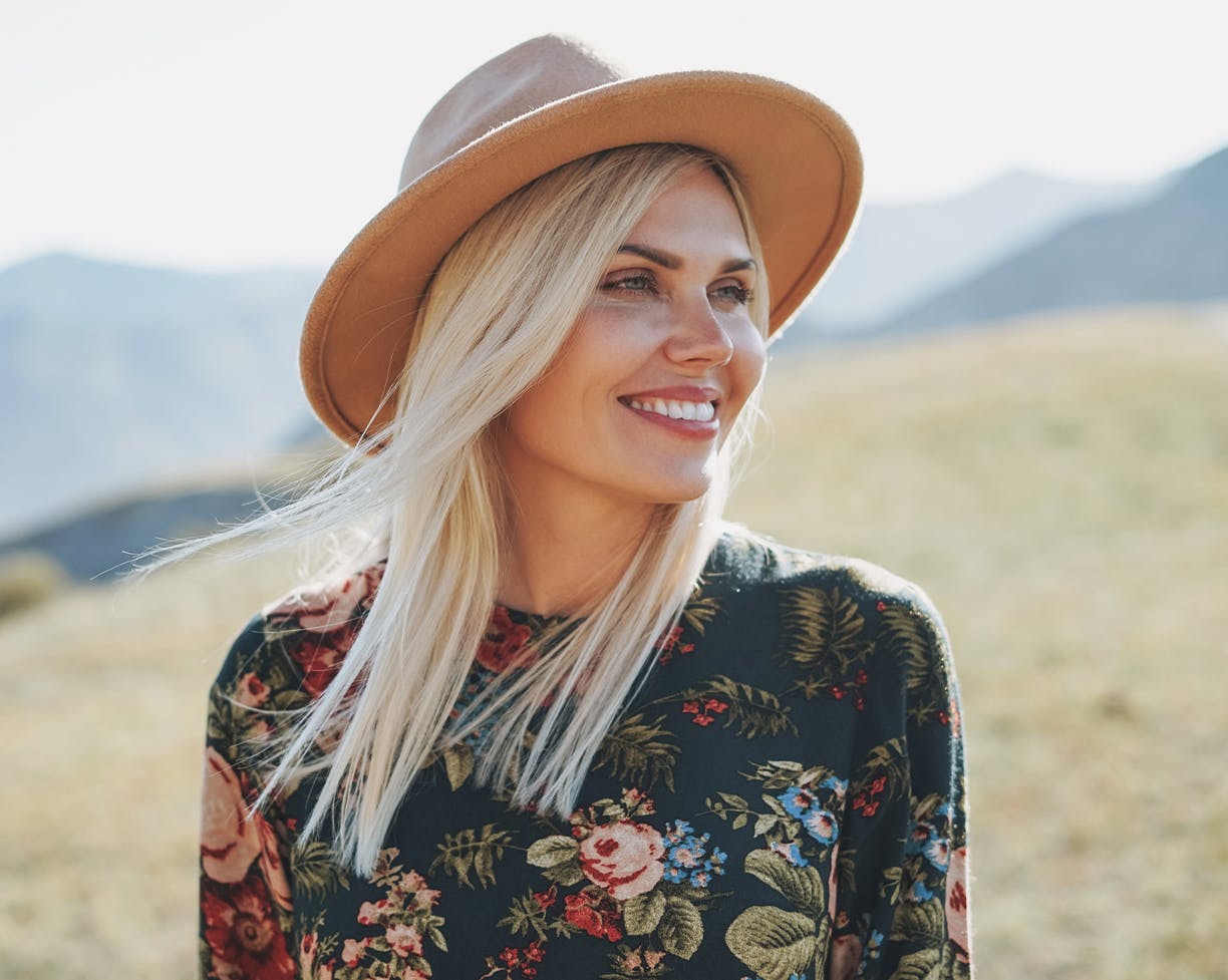 blonde woman wearing a hat and smiling