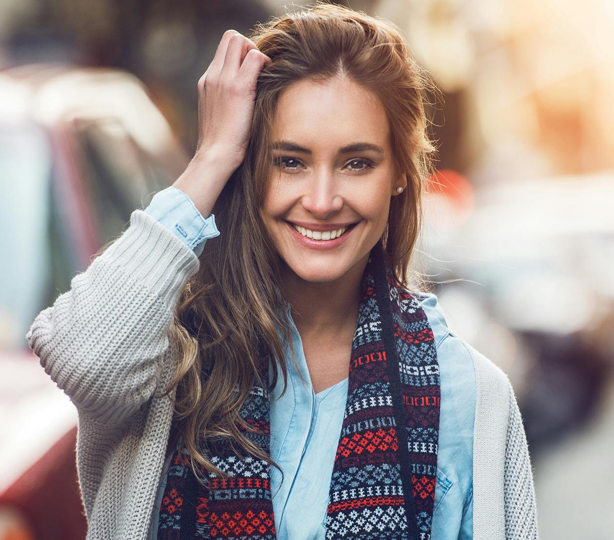Brown-haired woman wearing a scarf and smiling