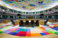vergaderzaal met kleurig tapijt en ronde vergadertafel