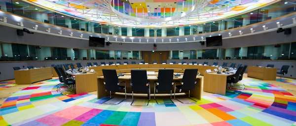 vergaderzaal met kleurig tapijt en ronde vergadertafel