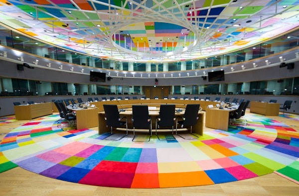 vergaderzaal met kleurig tapijt en ronde vergadertafel