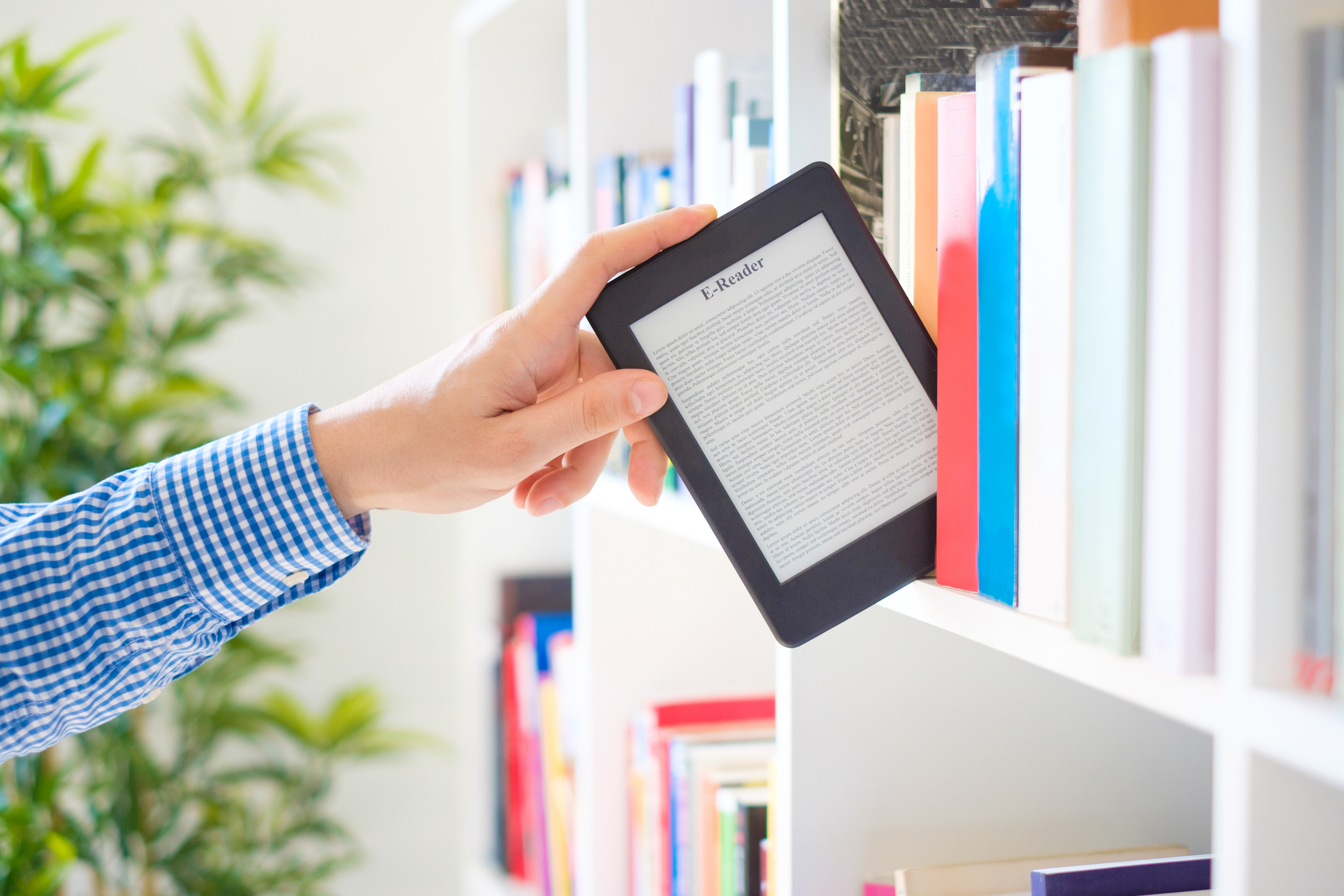 hand die e-reader van boekenplank haalt