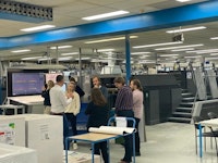Vijf studenten krijgen uitleg in de productiehal van drukkerij wilco