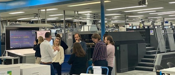 Vijf studenten krijgen uitleg in de productiehal van drukkerij wilco