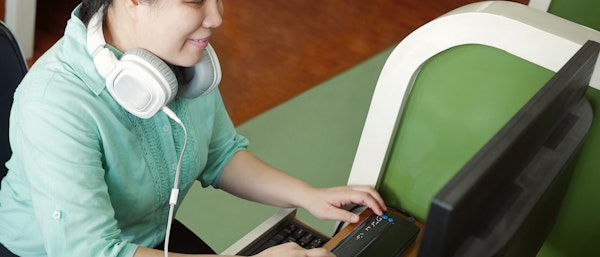 Vrouw leest met brailleregel van een computer beeldscherm