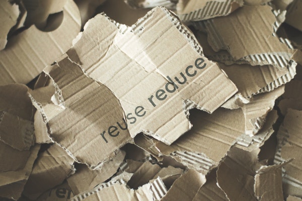Stuk karton met de tekst Reuse Reduce