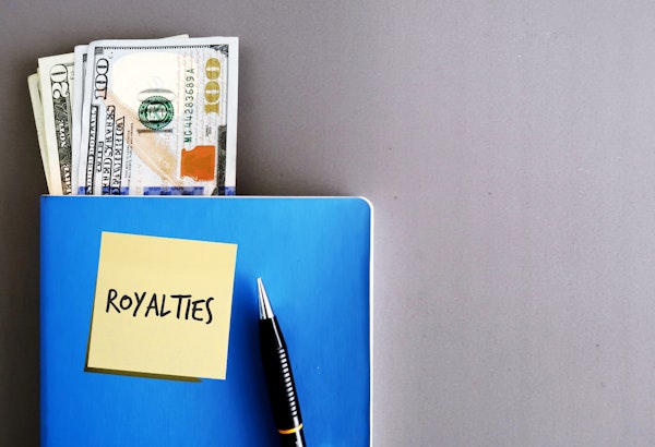 boek met geldbiljetten eruit gestoken. Post it op het boek met de tekst 'Royalties'.