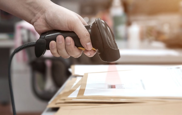 decoratief: hand die met een scanner een barcode op een document scant