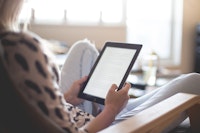 een vrouw leest een boek op haar e-reader