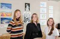 Drie illustratoren elk naast hun eigen werk.