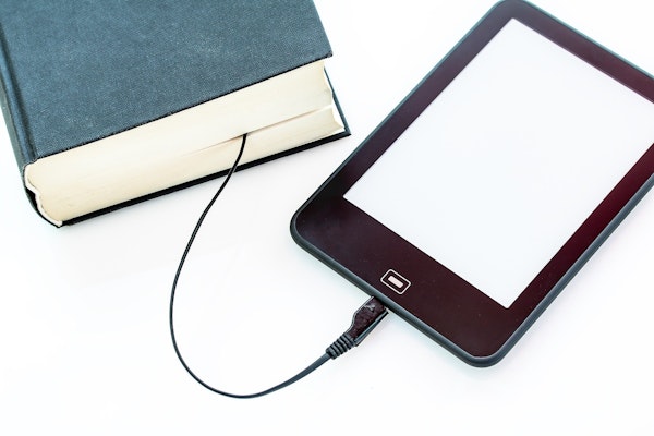 E-reader met oplaadkabel naar fysiek boek