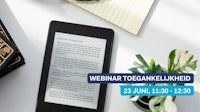 e-reader op een tafel met een notitieblok en een plantje