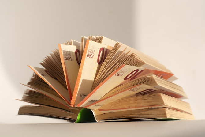 Opgeslagen boek met tien euro biljetten tussen de bladzidjes