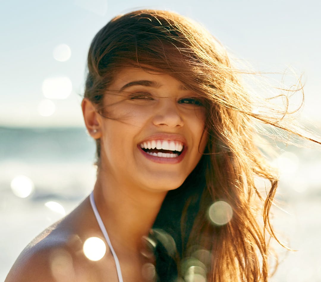Woman outside in the sun laughing
