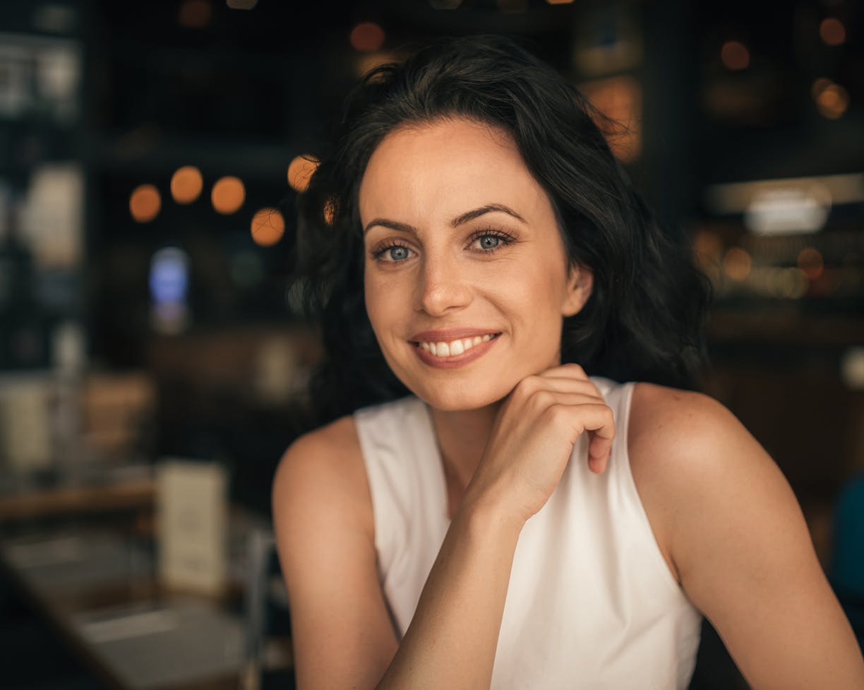 Woman in white sitting at a table in a restaurant