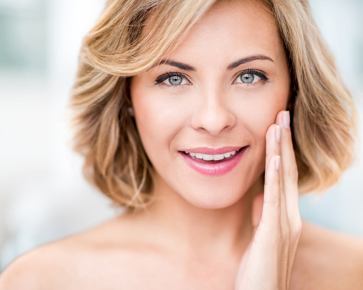 Woman with a bob touching side of her face