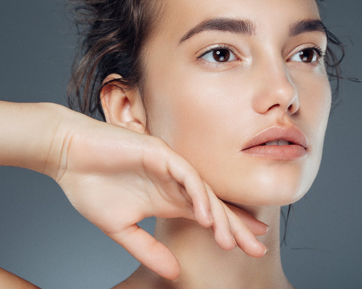 Close-up of a woman touching her face with back of her hand