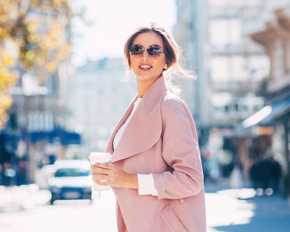 Woman crossing a street in a pink coat