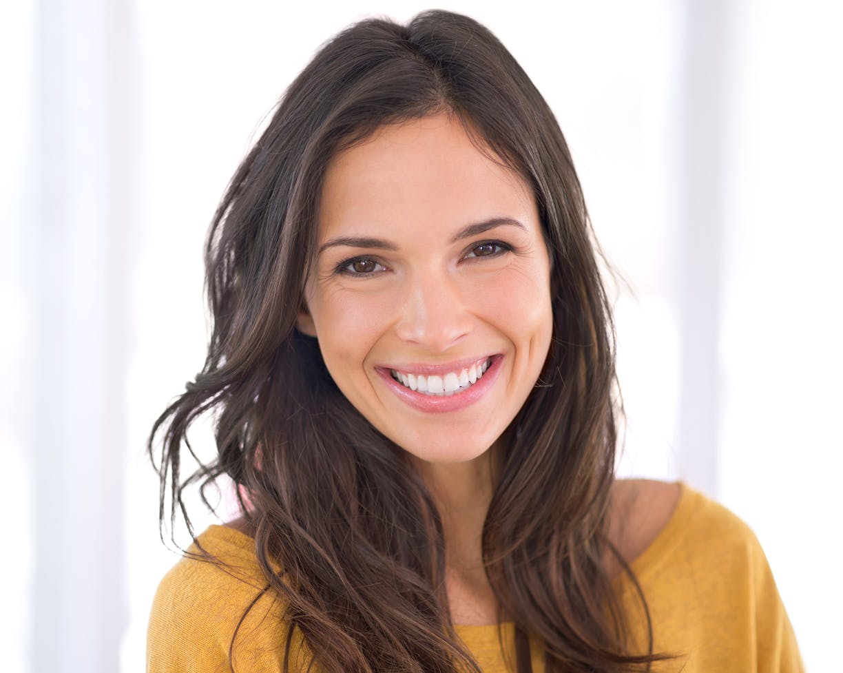 Brunette woman in a yellow top smiling