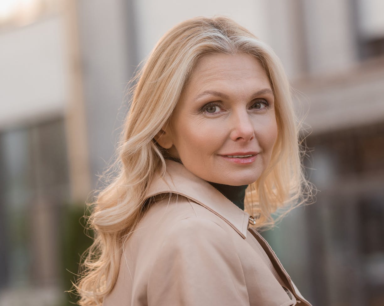Blonde woman wearing a jacket outside