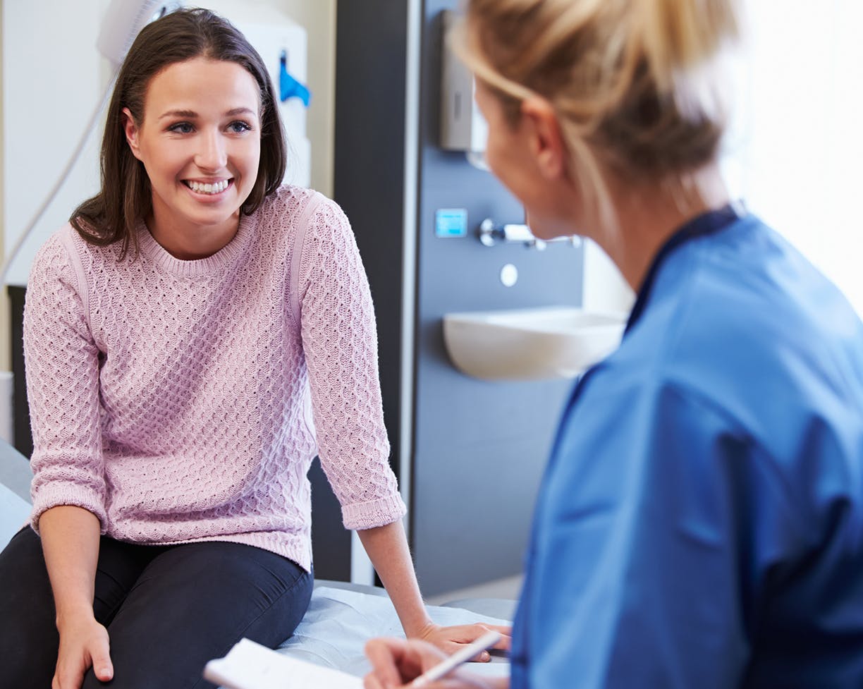 A doctor talking to a patient and taking notes