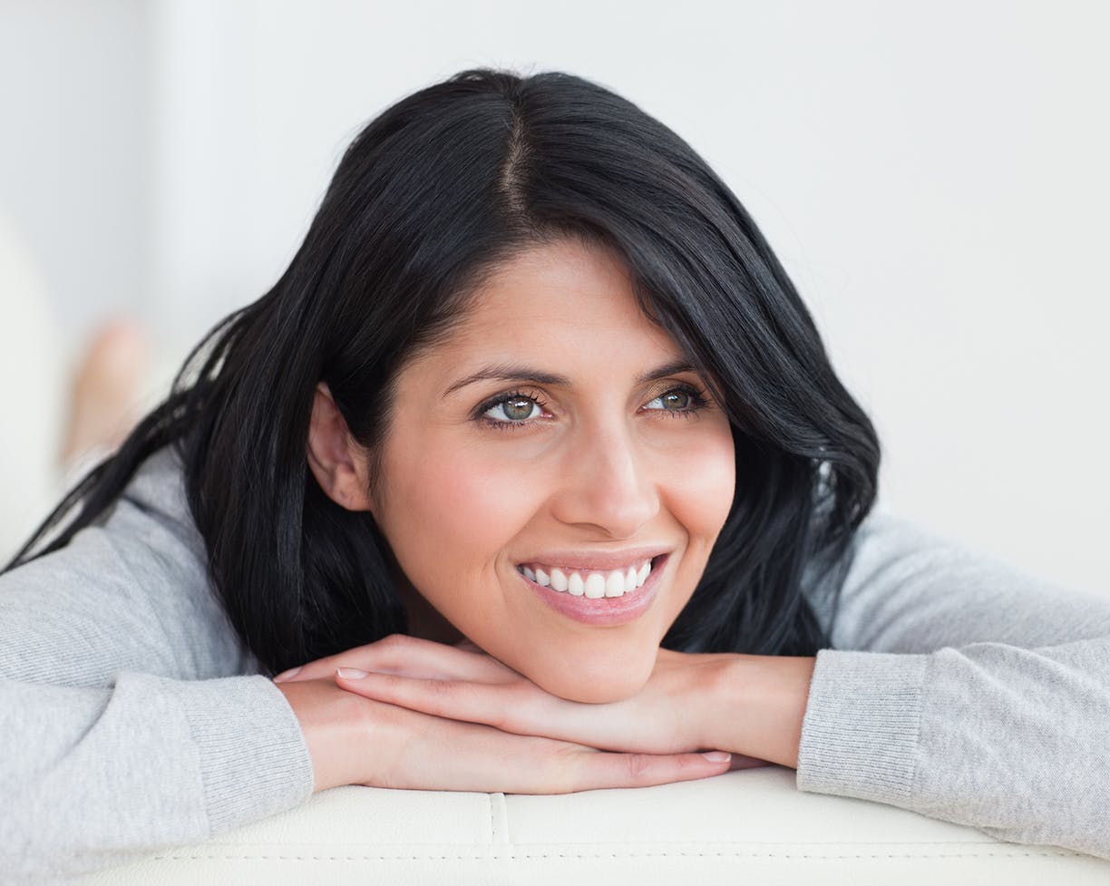 Brunette woman laying with her head in her hands