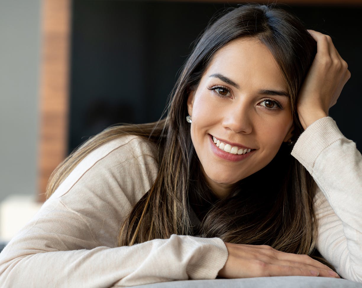 Woman on her stomach with her head in her hand