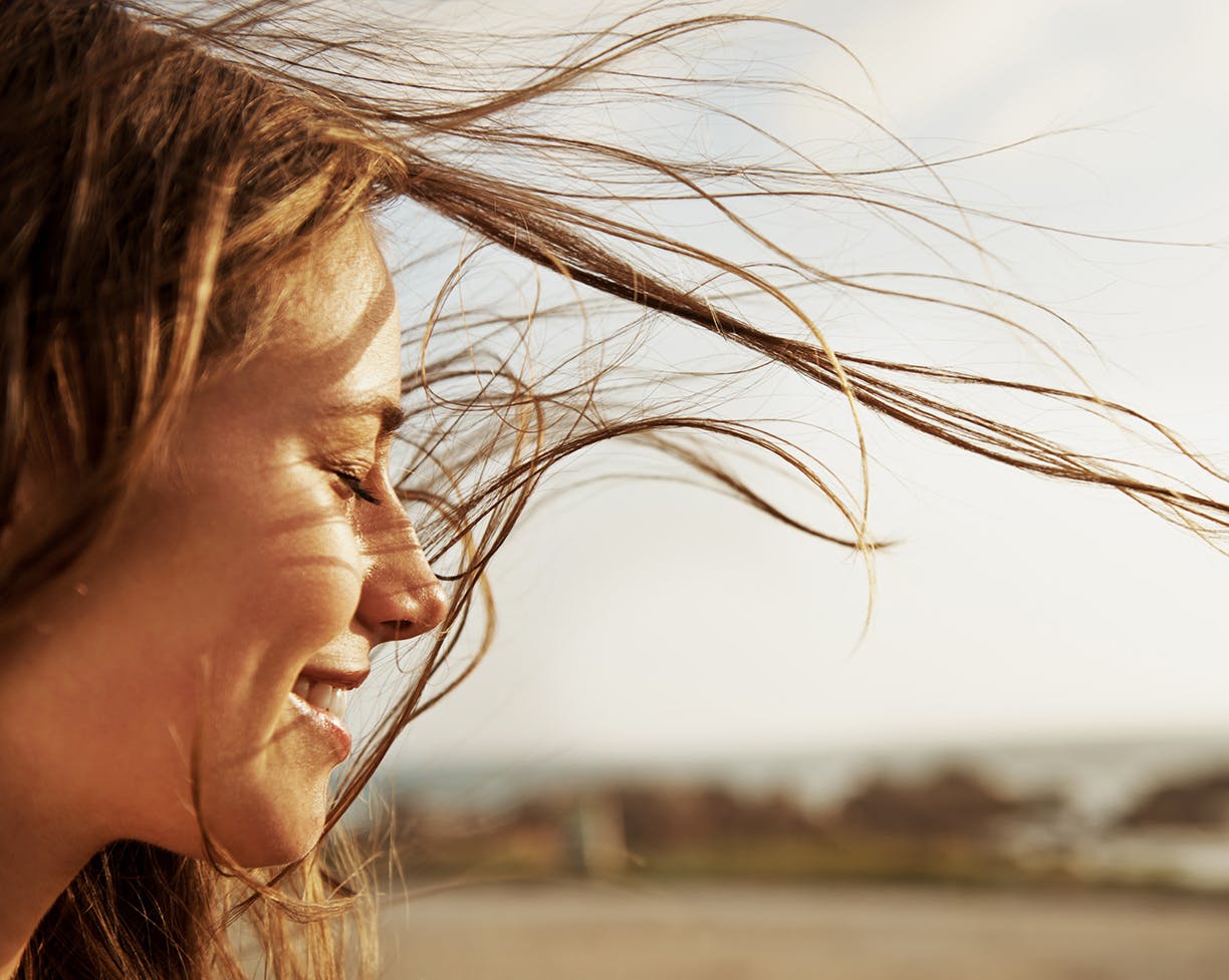 Side of a woman's face with her hair blowing in the wind