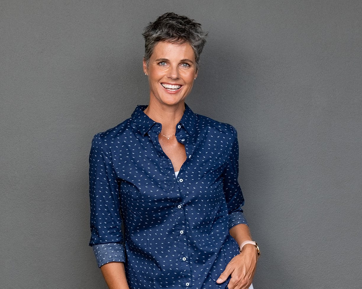 Woman in a blue button-up shirt smiling